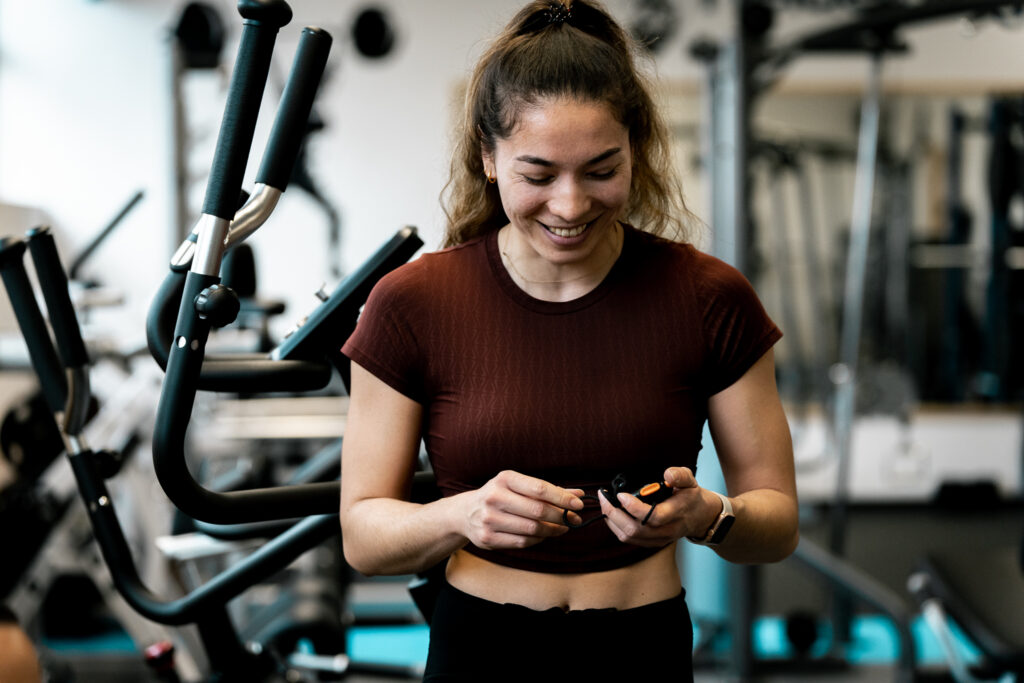 Personal Trainerin Ellise Meyer mit Stoppuhr in der Hand.