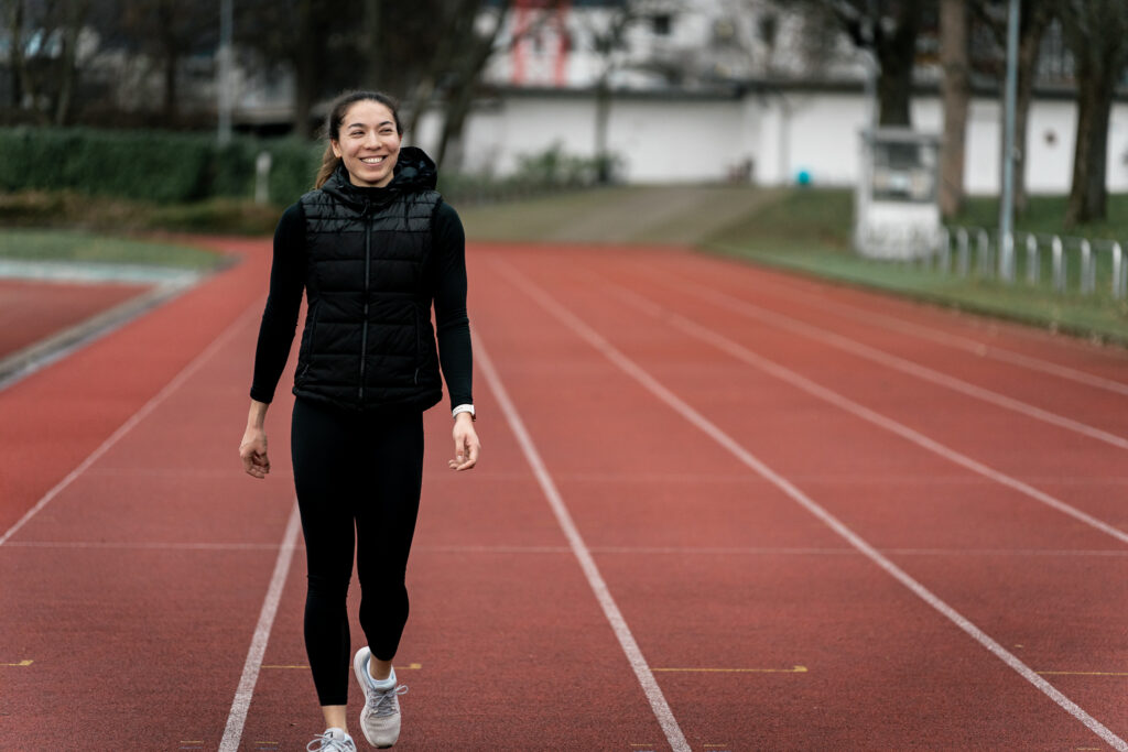 Personal Trainerin Ellise Meyer mit Lächeln auf der Laufbahn